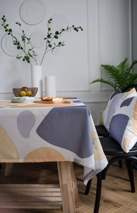 Detailed view of Nordic style tablecloth with abstract yellow and grey pebble prints