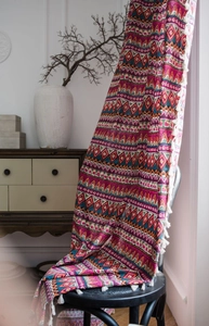 Detail of red Bohemian cotton linen curtain featuring geometric patterns and white tassels