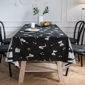 Modern black tablecloth with white musical instrument prints on a dining table
