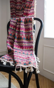 Detail of red Bohemian printed curtain with cotton linen fabric and white cotton tassels