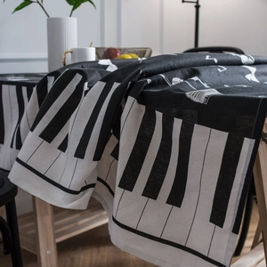 Minimalist piano keyboard tablecloth with music notes on a wooden dining table