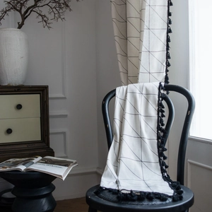 White linen curtain with black geometric grid print and fringe trim for home decor