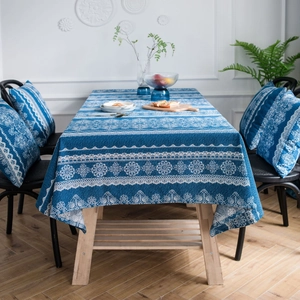 Mantel vintage con encaje azul y cojines a juego sobre una mesa de madera