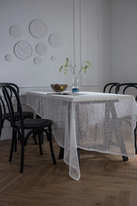 Close-up of intricate lace hollow-out pattern and texture on a white tablecloth