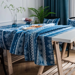 Mantel vintage azul oscuro con estampado de encaje blanco en mesa de madera moderna