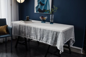 Detail of white lace tablecloth with hollow geometric diamond patterns and fine texture