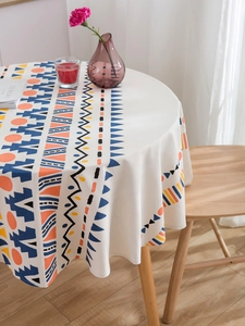 Détail du motif géométrique bohème sur nappe ronde beige avec un beau tombé de tissu