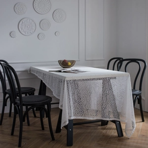 Modern white lace tablecloth with geometric hollow patterns on a dining table