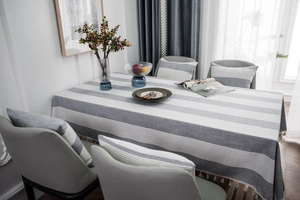 Close-up of grey striped tablecloth with elegant tassels and matching chair cushions