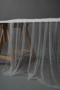 Macro detail of white sheer pearl mesh fabric for dessert table and photography backdrops