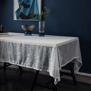 White rectangle lace tablecloth with geometric diamond patterns on dark wood table