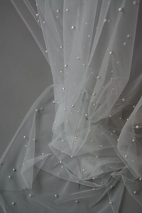 Detailed view of white pearl sheer tulle fabric for elegant dessert table decoration