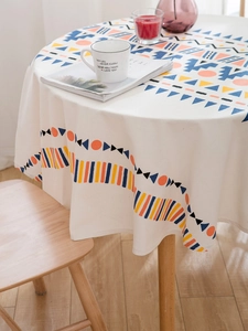 Détail d'une nappe ronde bohème avec motifs géométriques colorés et texture en coton et lin