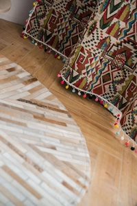 Detail of colorful Bohemian geometric jacquard fabric with multi-color pom pom trim edges
