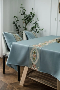 Detailed embroidery on light blue luxury tablecloth with elegant floral patterns
