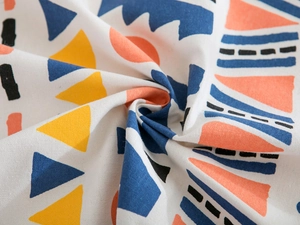 Vue détaillée du tissu bohème aux motifs géométriques imprimés bleus et oranges