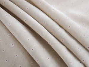 Detailed macro view of cotton linen fabric with white daisy print and natural texture