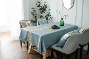 Close-up of elegant floral embroidery on beige classic tablecloth with premium silk texture