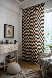 Detail of bohemian curtain with black tassels and golden wave pattern on cotton linen fabric