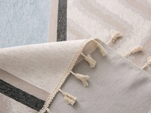 Detailed macro view of chenille jacquard fabric with geometric patterns and beige tassels