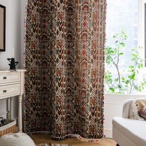 Bohemian style curtain with colorful geometric patterns and decorative pom-poms tassels