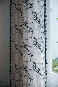 Dettaglio della tenda con stampa marmo bianco e rifiniture di frange con nappe nere