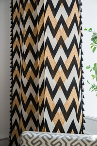 Detail of bohemian cotton linen curtain with black tassel and mustard chevron pattern