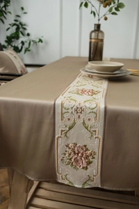 Detail of elegant champagne tablecloth with exquisite floral embroidery on dining table