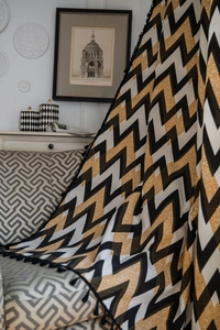 Detail of bohemian cotton linen curtain with black gold wave pattern and black ball tassels