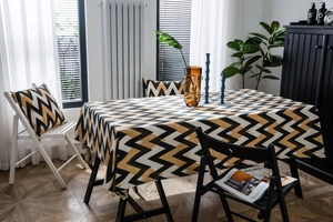 Close-up of golden wavy geometric pattern on thick cotton linen tablecloth with pillows