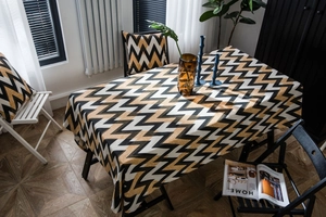 Detail of bohemian gold wavy pattern tablecloth with matching cushion in living room