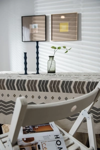 Macro detail of geometric linen tablecloth with ethnic patterns under soft sunlight shadows