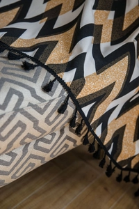 Detailed view of bohemian cotton linen curtain with black tassels and chevron patterns
