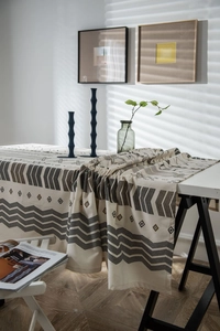 Detail of bohemian geometric print tablecloth in beige linen fabric with black patterns