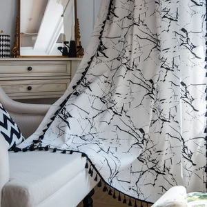 Coperta moderna bianca con stampa marmorizzata e frange nere su divano bianco