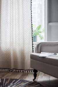 Detailansicht beige Leinenvorhang mit dunkler Sternbestickung und schwarzen Quasten