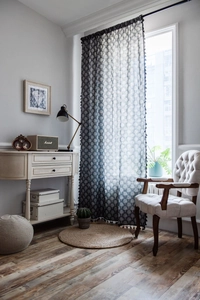 Detail of cotton linen curtain with tree print, black tassel fringe and rod pocket design