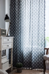 Detail of navy blue linen curtain with white tree print and black tassel fringe borders