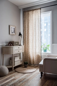 Detail view of dandelion print linen curtain with elegant black pompom tassel trim edges