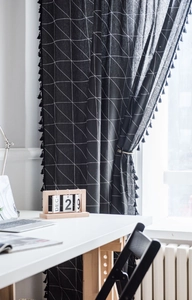 Vue détaillée du rideau en coton et lin noir à motif géométrique avec bordure à pompons