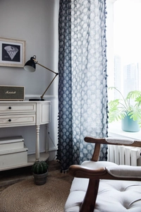 Close-up of cotton linen curtain with forest tree print and navy blue fringe tassels
