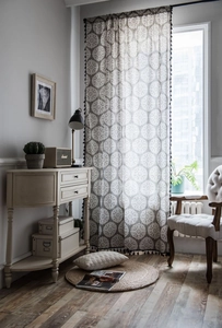 Détail du rideau en coton lin gris avec motifs floraux rétro et pompons noirs décoratifs