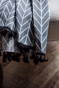 Detailed texture of grey geometric cotton linen curtain with black tassel fringe accents