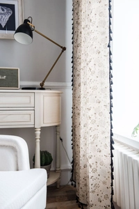 Close-up of dandelion print linen curtain with decorative dark blue tassel edge detail
