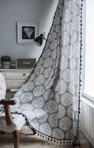 Détail du rideau à imprimé mandala avec pampilles à franges noires et texture tissu