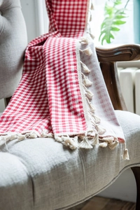 Detail of red and white gingham kitchen curtain with delicate white tassel fringe trim