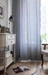 Close-up of navy wave pattern curtains with black tassels and semi-sheer cotton linen fabric