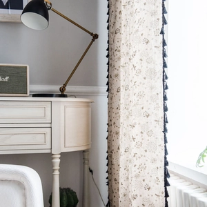 Linen cotton dandelion print curtain with blue tassels hanging in a cozy room