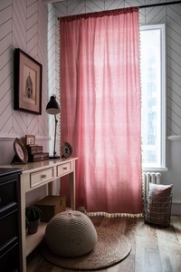 Close-up of red gingham curtain fabric with beige fringe tassels and rod pocket detail