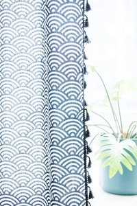 Detail view of blue wave pattern cotton linen curtain with black tassel trim edges